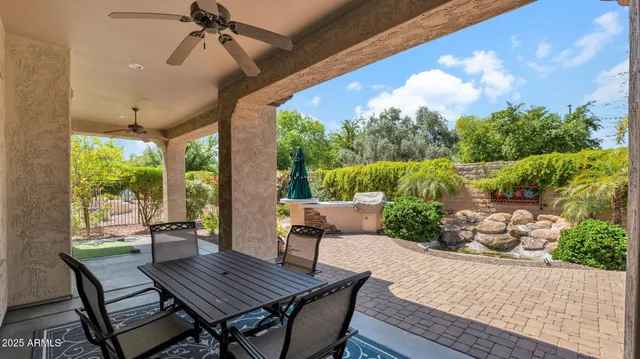 a view of a backyard with table and chairs potted plants and palm tree