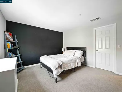 a bedroom with a bed a flat screen tv and window