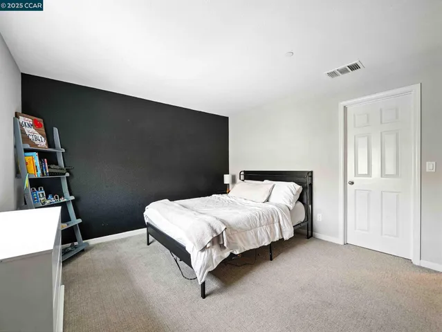 a bedroom with a bed a flat screen tv and window