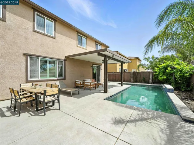 a view of a patio with table and chairs potted plants and a palm tree