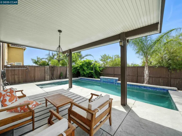 a swimming pool with outdoor seating and yard
