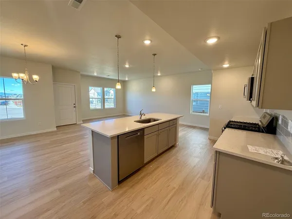 a kitchen with a sink and wooden floor