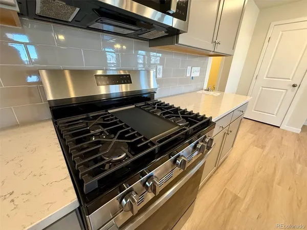a stove top oven sitting inside of a kitchen