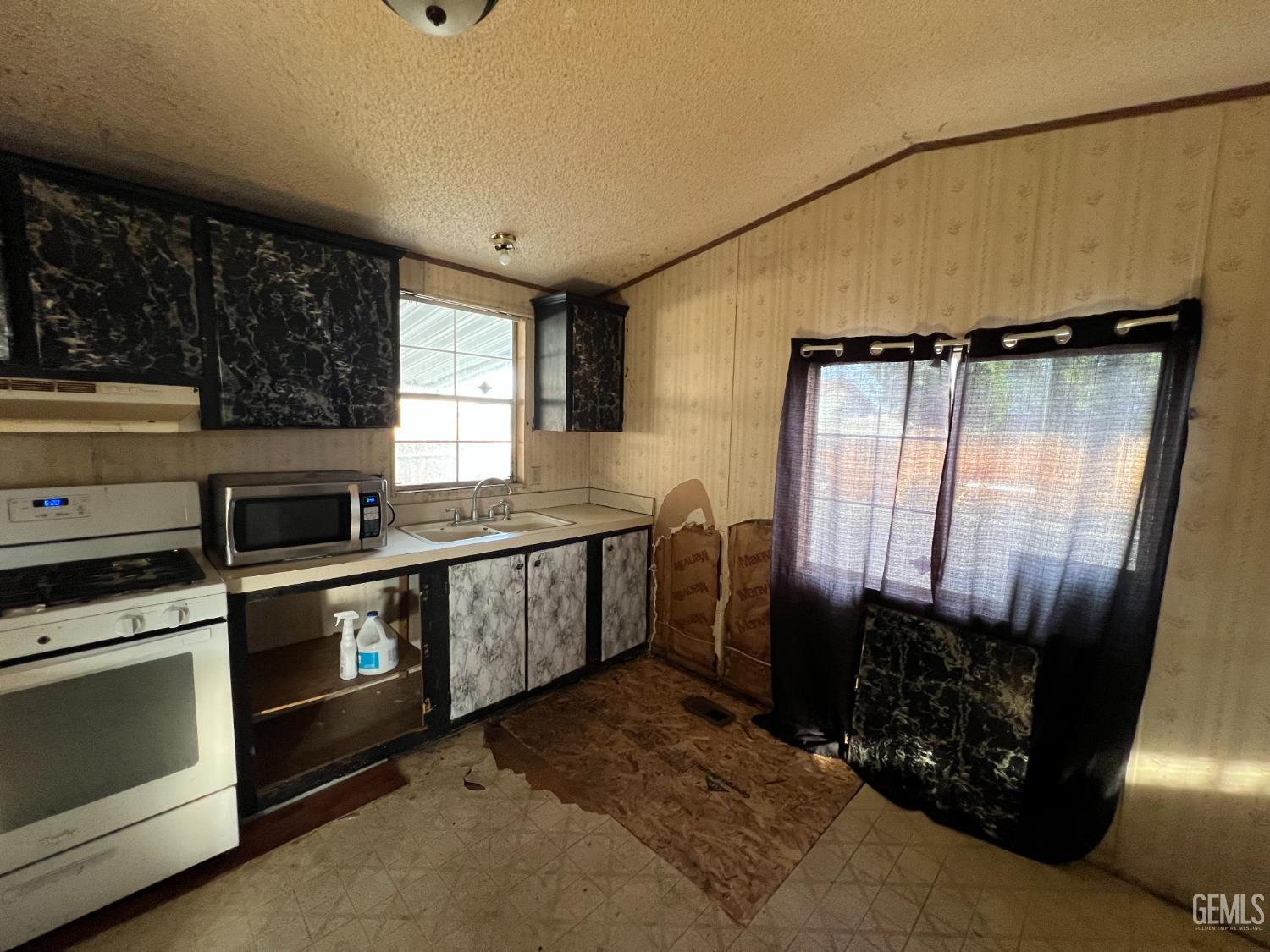 Undisclosed Address Bakersfield, CA 93309 - Photo 13 of 14 a kitchen with granite countertop a stove a sink and a microwave
