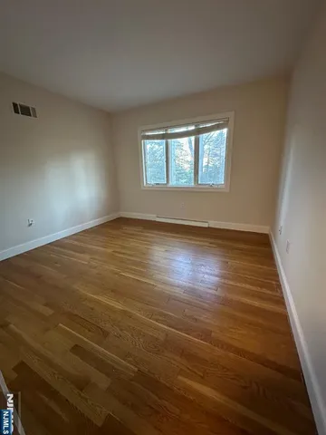 a view of a room with wooden floor
