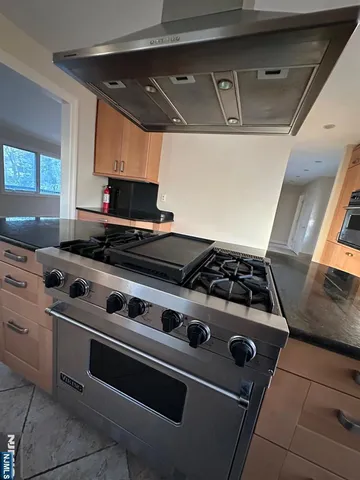 a kitchen with stainless steel appliances granite countertop a refrigerator and a stove top oven