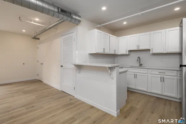 a kitchen with cabinets appliances a sink and a counter top space