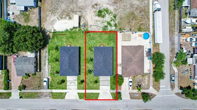 a view of a brick house with a yard and plants