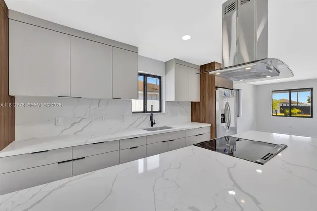 a kitchen with stainless steel appliances granite countertop a sink and a refrigerator