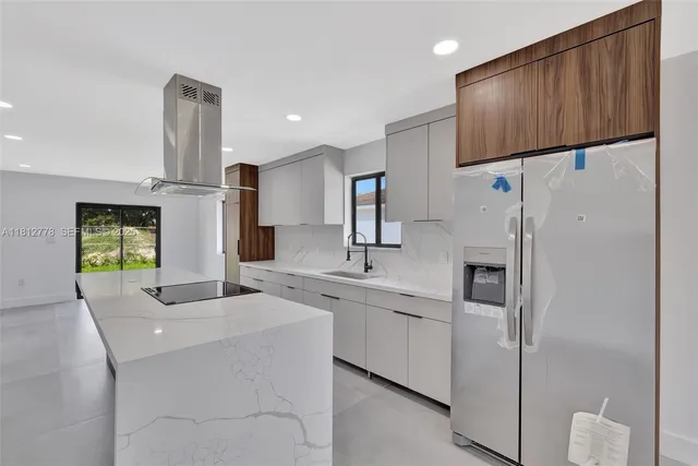 a large kitchen with a large counter top and stainless steel appliances