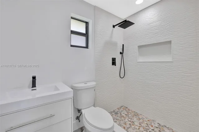 a bathroom with a granite countertop sink toilet and shower