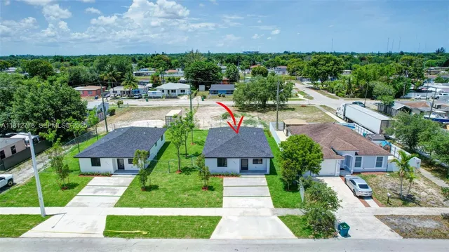 a aerial view of a house with a yard table and chairs