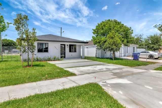 a house with green field in front of it
