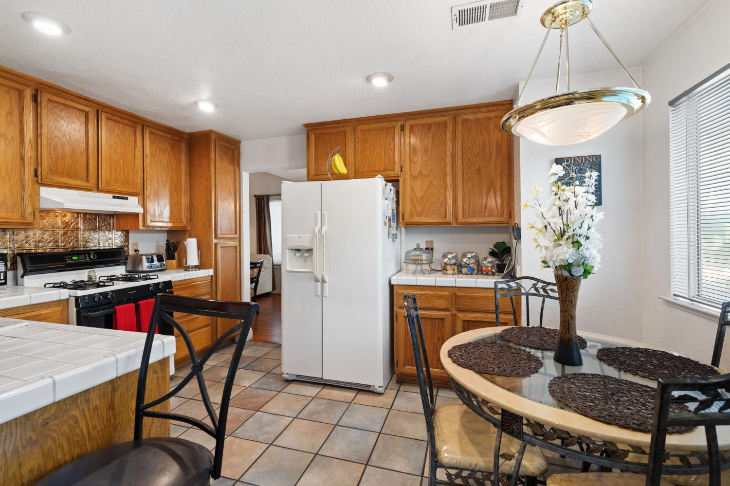 3941 Grey Livery Way Antelope, CA 95843 - Photo 9 of 28 a kitchen with refrigerator a stove a sink and a dining table with wooden floor
