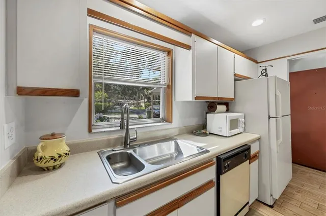 a kitchen with granite countertop a sink appliances and cabinets