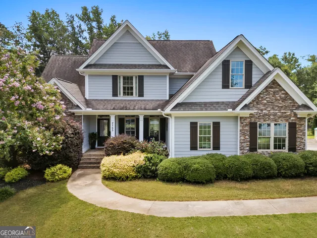 a front view of a house with yard and green space