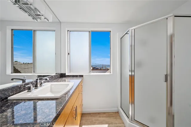 a bathroom with a granite countertop sink and a mirror