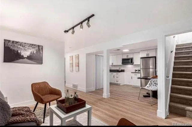 a living room with furniture and a wooden floor