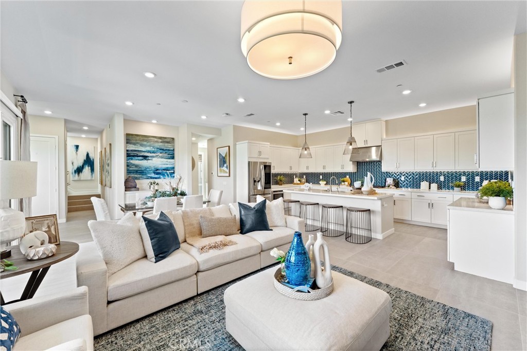 419 Transport Tustin, CA 92782 - Photo 11 of 58 a living room with white couches and a dining table with kitchen view