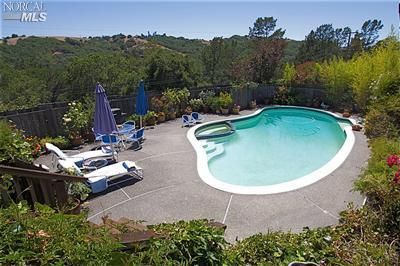 a view of a swimming pool with a yard and sitting area