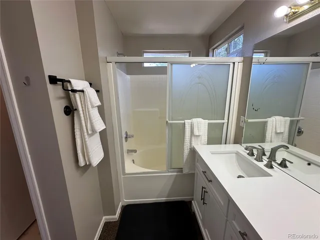a bathroom with a double vanity sink a mirror and shower