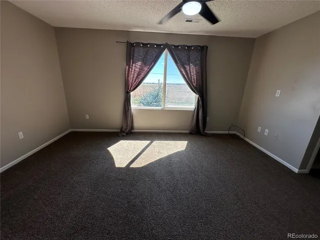 an empty room with a fireplace and windows