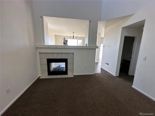 a view of an empty room with a fireplace and a window