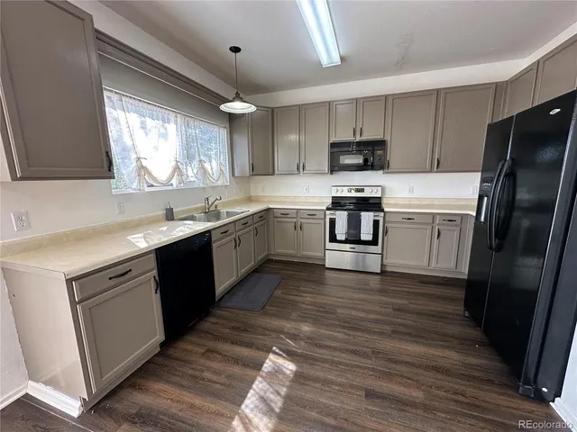 a kitchen with a sink cabinets stainless steel appliances and a window