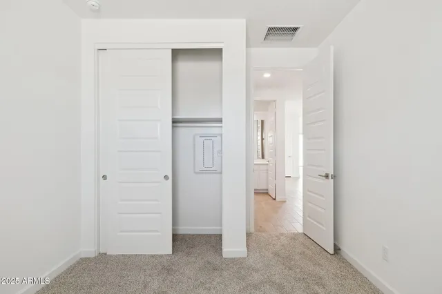 an empty room with closet and a bathroom