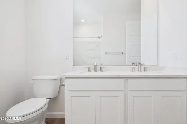 a bathroom with a granite countertop toilet sink and mirror