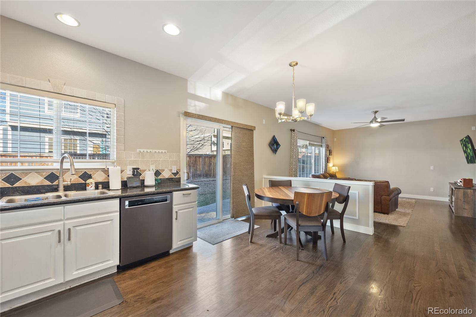1201 Riddlewood Road Highlands Ranch, CO 80129 - Photo 12 of 36 a dining room with wooden floor a chandelier a wooden table and chairs