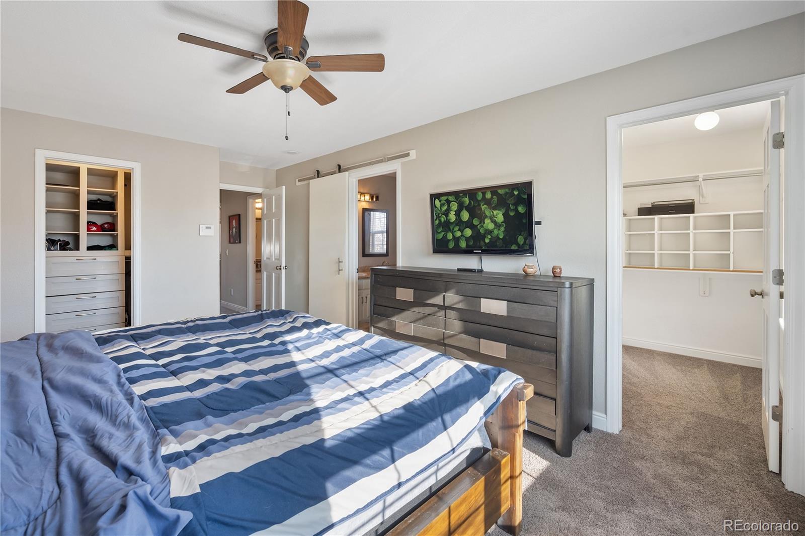1201 Riddlewood Road Highlands Ranch, CO 80129 - Photo 17 of 36 a bedroom with a bed and a flat screen tv