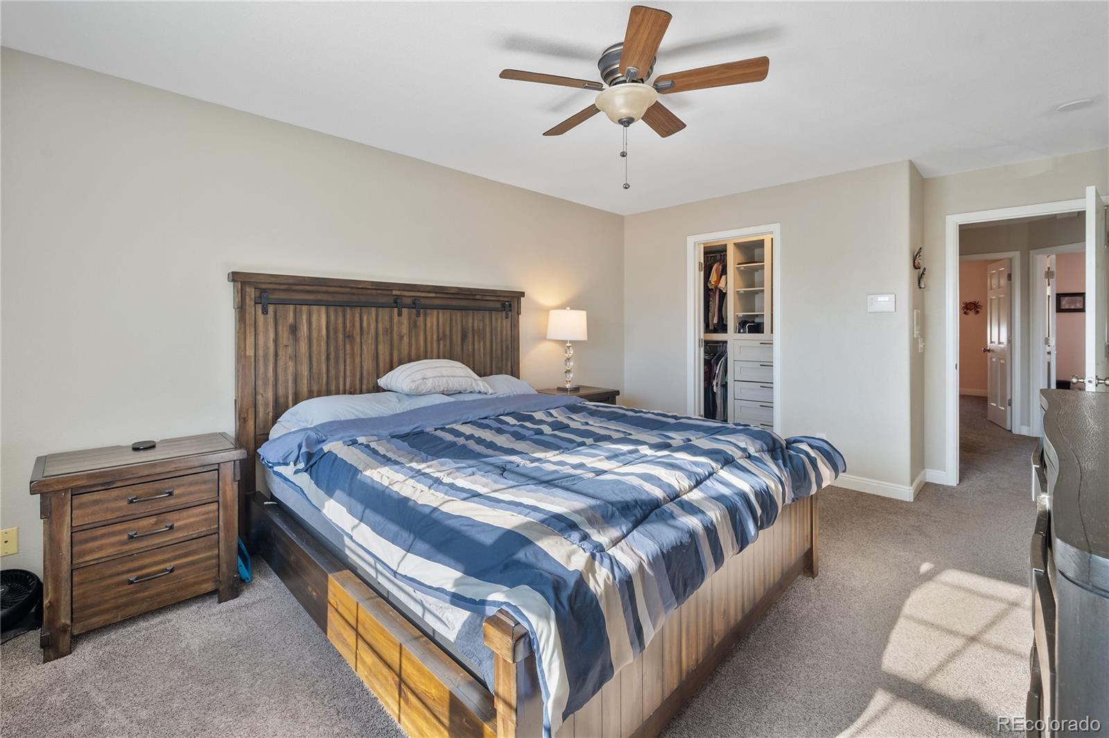 1201 Riddlewood Road Highlands Ranch, CO 80129 - Photo 18 of 36 a bedroom with a bed and a chandelier