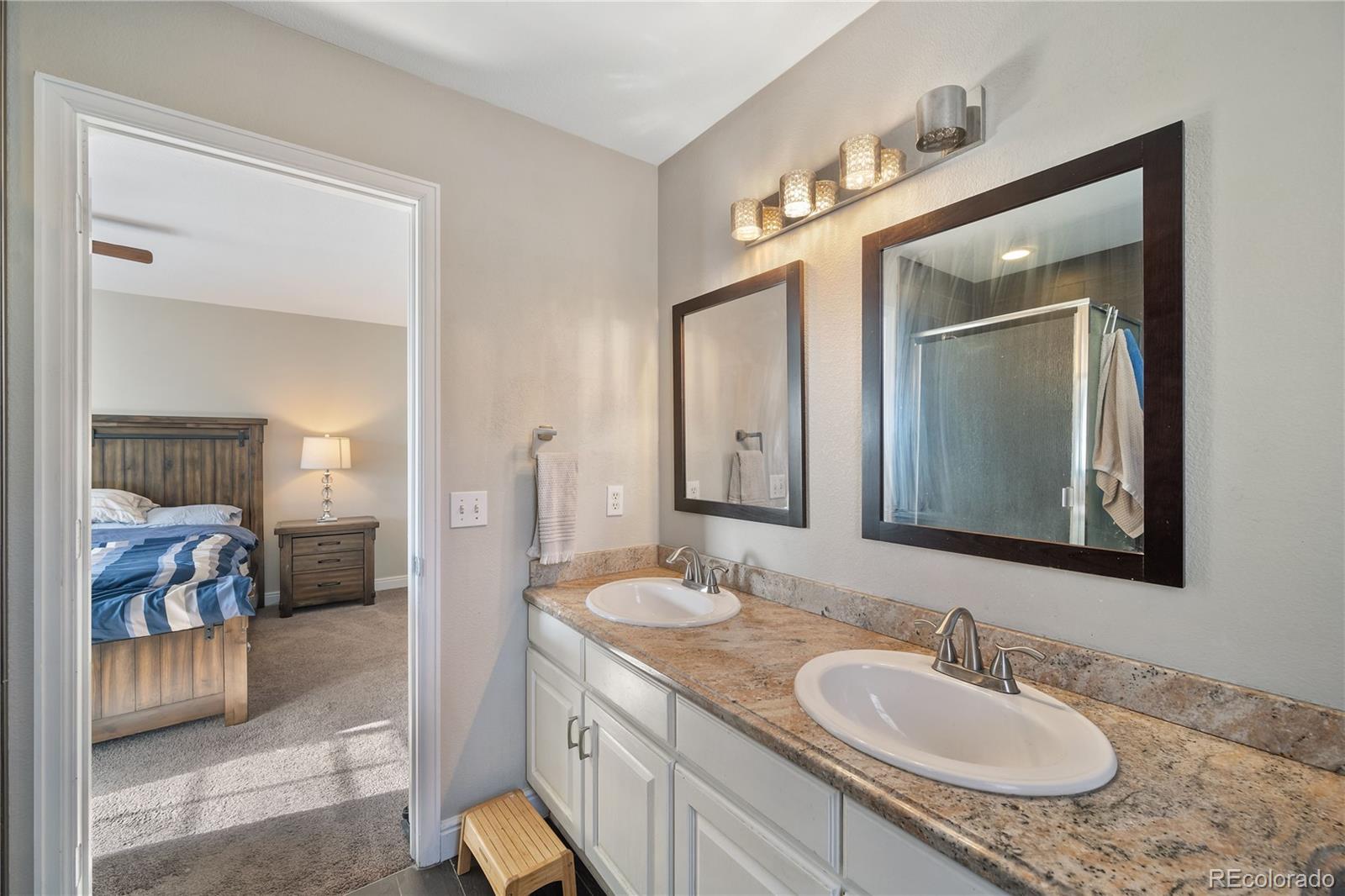 1201 Riddlewood Road Highlands Ranch, CO 80129 - Photo 23 of 36 a en suite bathroom with a double vanity sink and a mirror