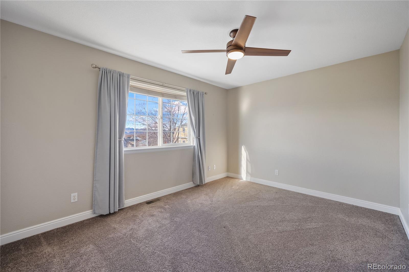 1201 Riddlewood Road Highlands Ranch, CO 80129 - Photo 27 of 36 an empty room with ceiling fan and windows