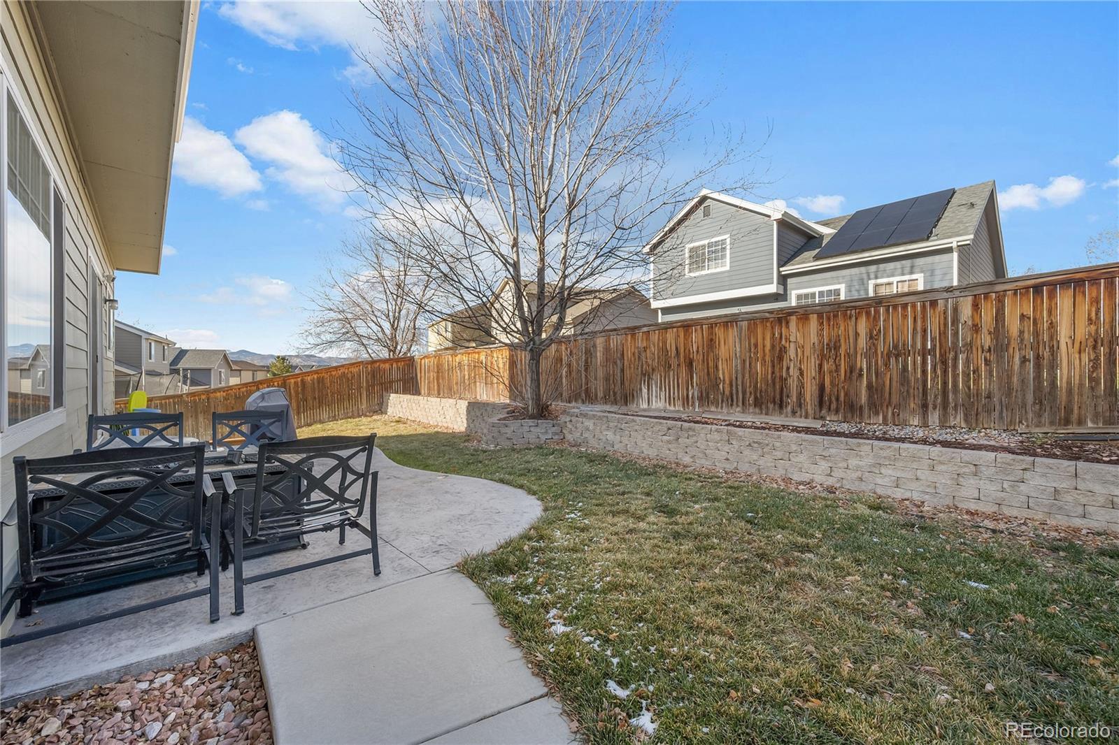 1201 Riddlewood Road Highlands Ranch, CO 80129 - Photo 34 of 36 a view of backyard with table and chairs and wooden fence