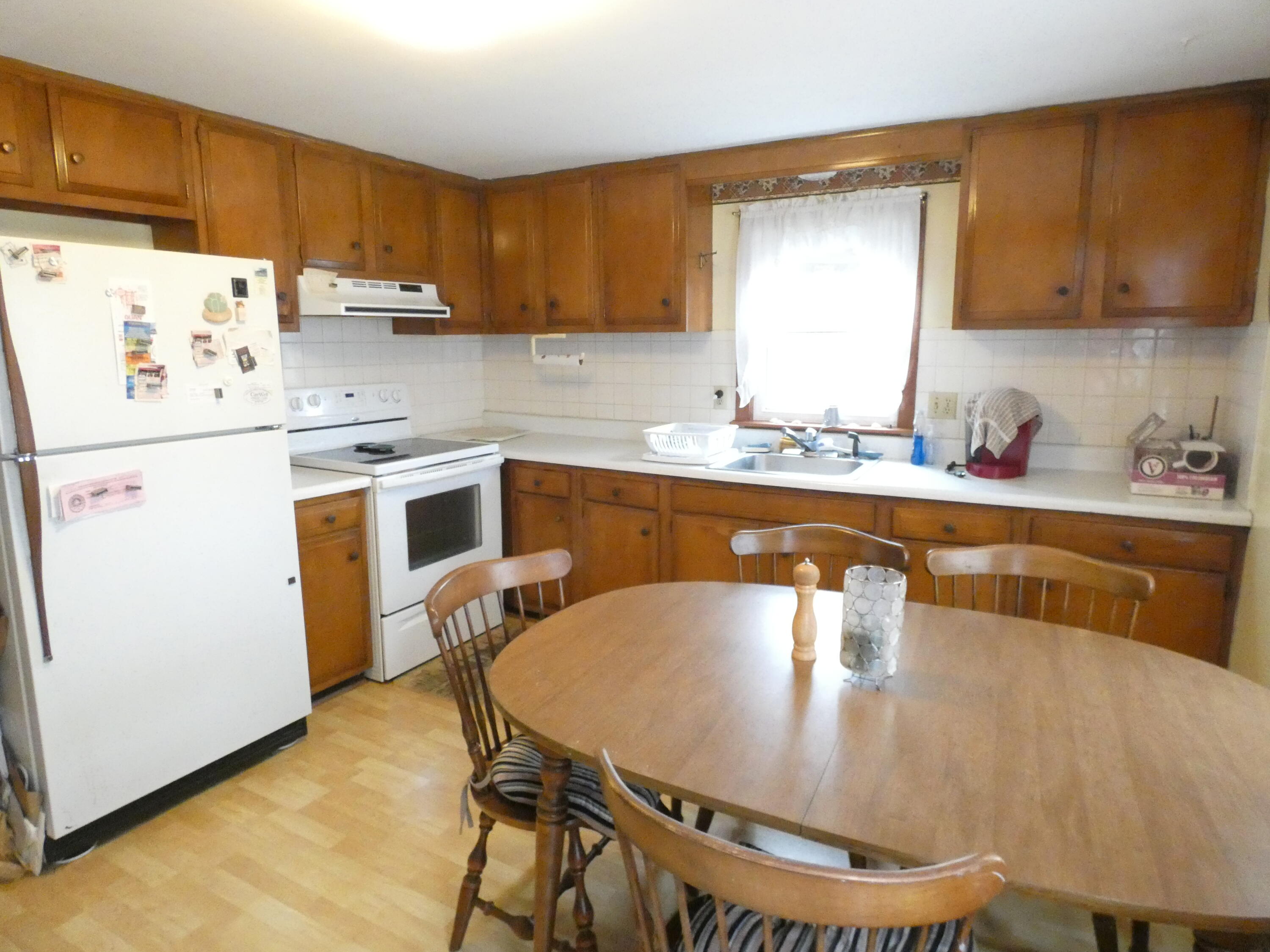 188 Swan River Road West Dennis, MA 02670 - Photo 25 of 39 a kitchen with stainless steel appliances granite countertop a sink a stove a refrigerator with a dining table and chairs
