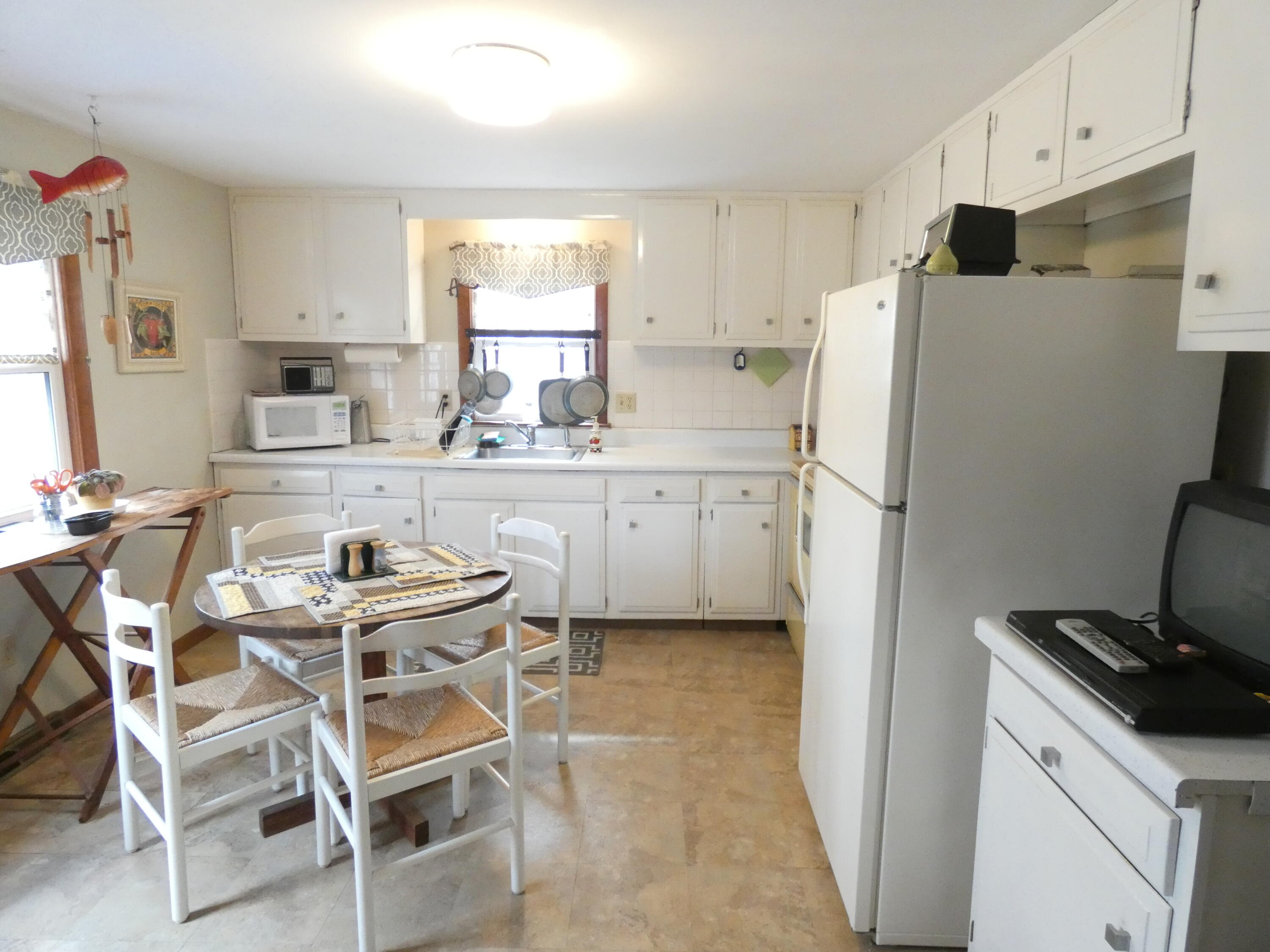 188 Swan River Road West Dennis, MA 02670 - Photo 7 of 39 a kitchen with refrigerator a stove a sink and cabinets