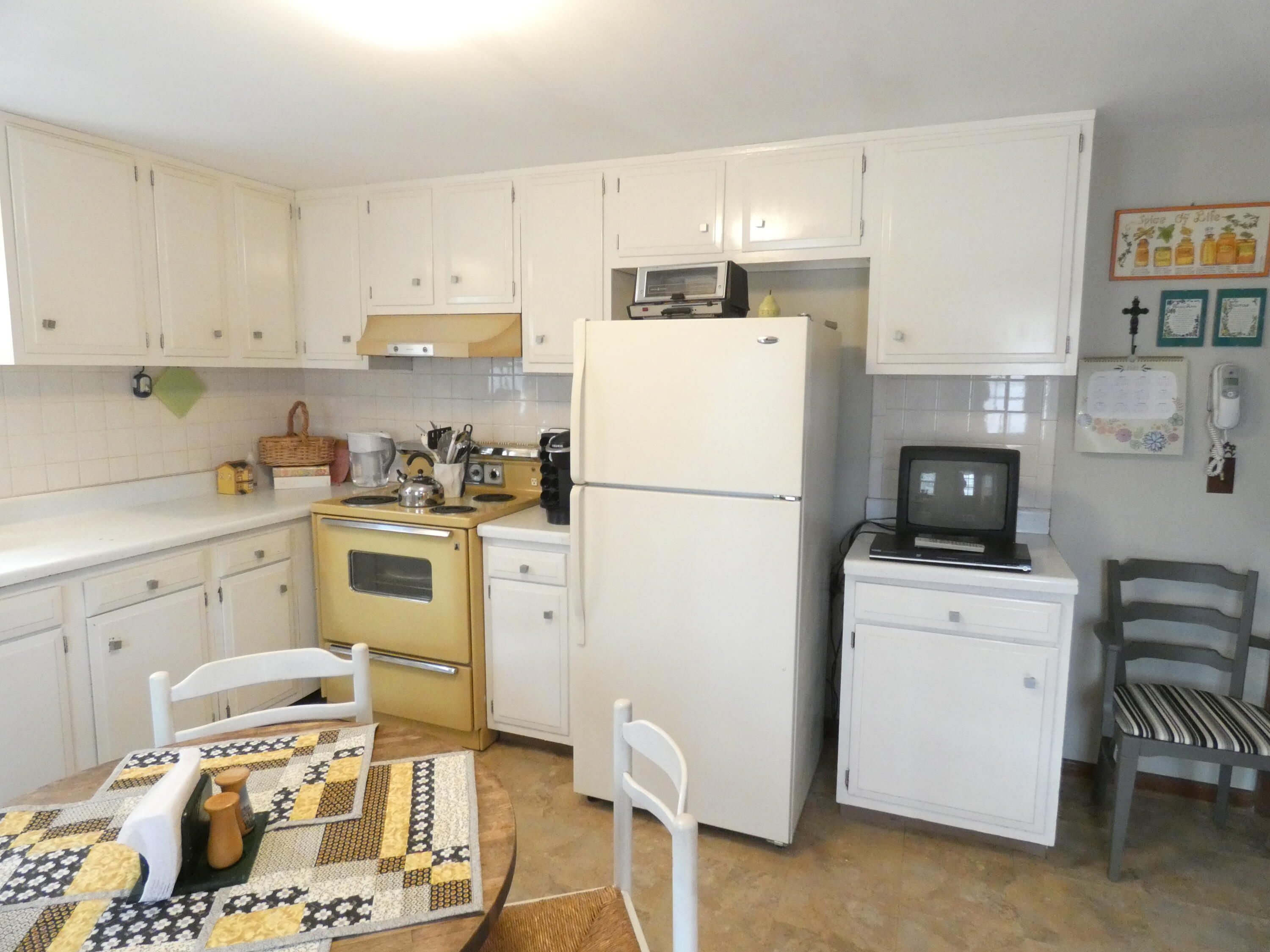 188 Swan River Road West Dennis, MA 02670 - Photo 8 of 39 a kitchen with a refrigerator a stove top oven a sink a dining table and chairs