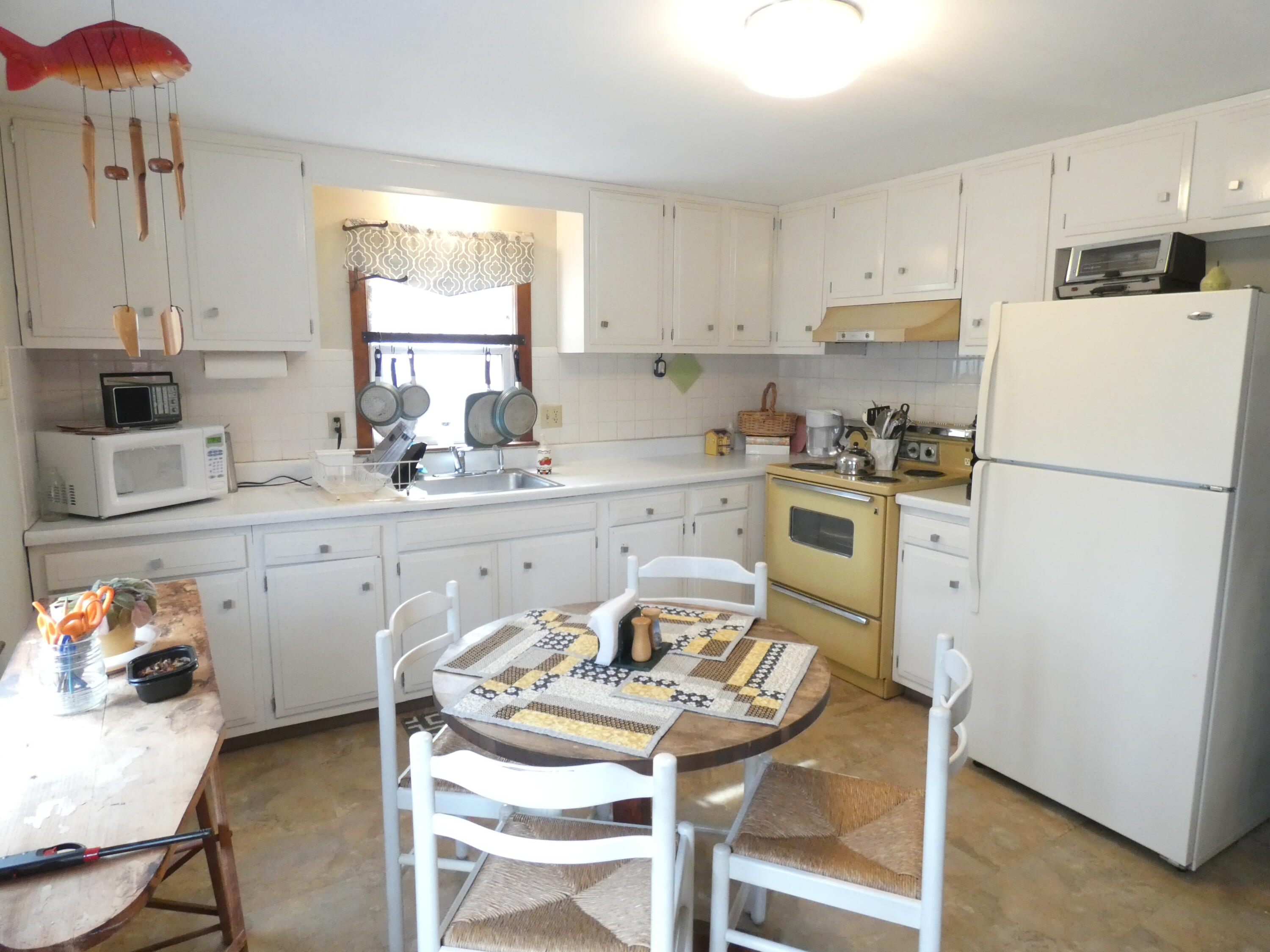 188 Swan River Road West Dennis, MA 02670 - Photo 9 of 39 a kitchen with a refrigerator a stove a sink dishwasher a dining table and chairs
