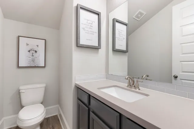 a bathroom with a toilet a sink and mirror