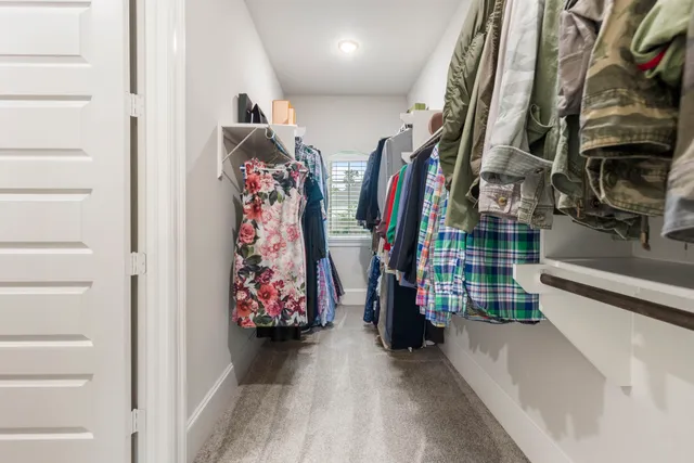 a view of walk in closet with clothes and shoes