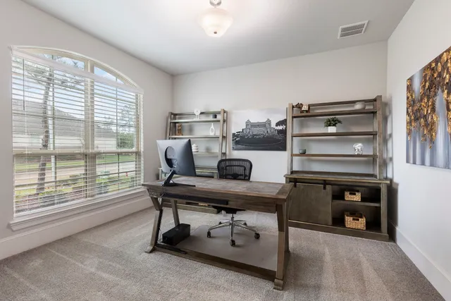 a view of a workspace with furniture and a window