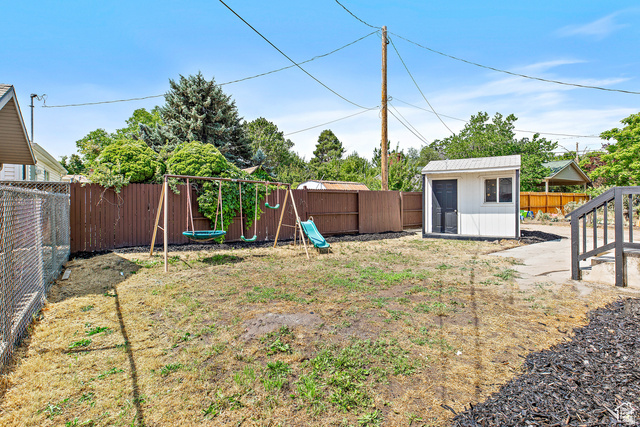372 East 400 North Springville, UT 84663 - Photo 27 of 27 Fenced backyard featuring a storage shed, wooden privacy fencing, chain link fencing, and exterior stairs