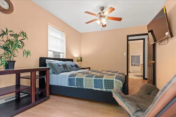 a bedroom with a bed next to a large window with a flat screen tv