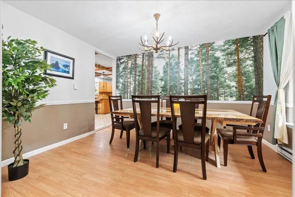 a dining room with furniture a chandelier and wooden floor