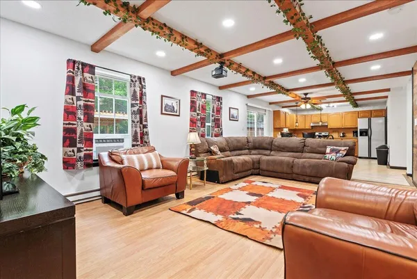 a living room with furniture kitchen view and a large window