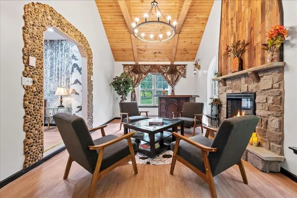 a dining room with furniture a fireplace and wooden floor