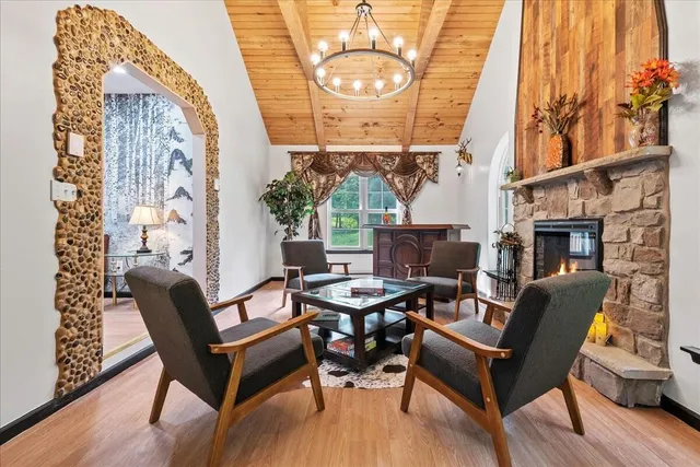 a dining room with furniture a fireplace and wooden floor