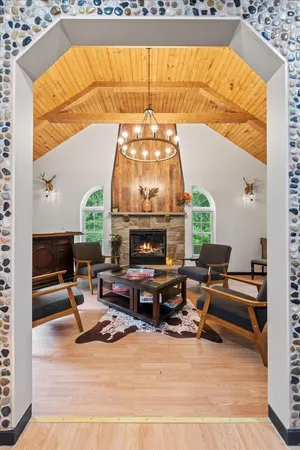 a living room with furniture a fireplace and a floor to ceiling window